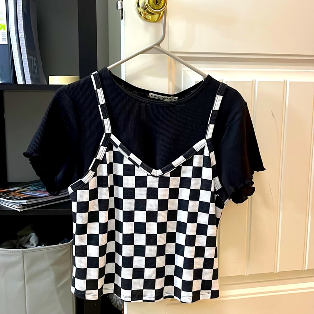 It has a checker, looking tank top which is connected to the black shirt.